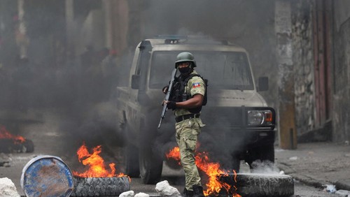 People react as they walk near a burning barricade set up in protest against the government and calling for the resignation of Prime Minister Ariel Henry, in Port-au-Prince, Haiti February 5, 2024. REUTERS/Ralph Tedy Erol