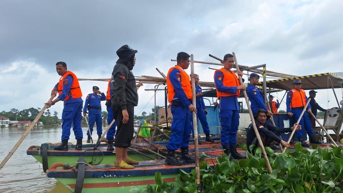 Personel Ditpolairud Polda Jambi membersihkan Danau Sipin dan menebar benih ikan.
