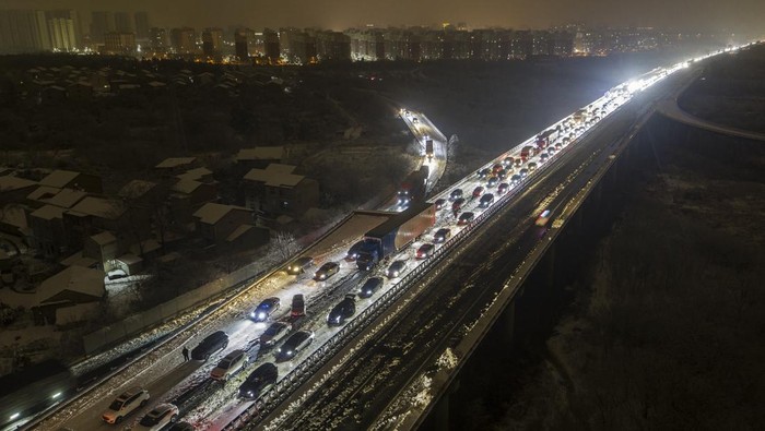 Potret Ribuan Kendaraan Terjebak Macet saat Mudik Imlek di China A migrant worker carrying his belonging leaves a village to catch his transport on the outskirt of Beijing, Tuesday, Feb. 6, 2024. Widespread snowfall and freezing weather continued in central and eastern China disrupting transport and stranding travelers amid the annual Lunar New Year travel rush. (AP Photo/Andy Wong)