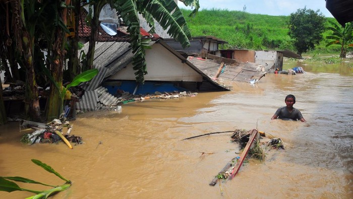 Warga naik sepeda menerjang banjir di Desa Gubug, Gubug, Grobogan, Jawa Tengah, Selasa (6/2/2024). Banjir akibat hujan deras serta jebolnya beberapa tanggul sungai Tuntang itu merendam 2.662 unit rumah, 56 hektare persawahan, enam sekolah dan sejumlah rumah ibadah serta jalan utama yang menghubungkan Purwodadi-Semarang masih dialihkan ke jalur alternatif. ANTARA FOTO/Yusuf Nugroho/nym.