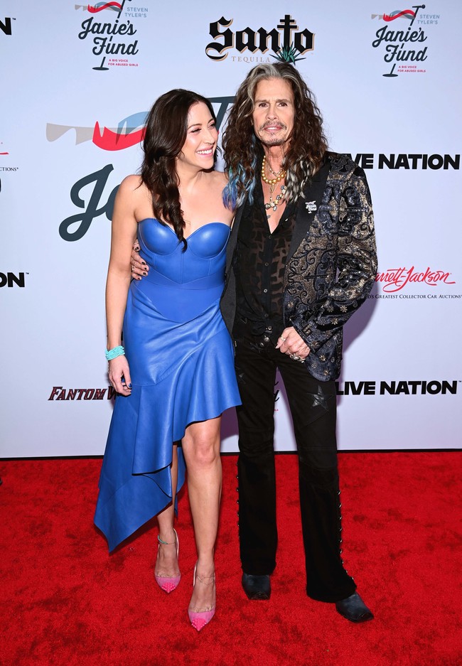 Aimee mencuri perhatian dengan gaun strapless biru terang berpotongan korset dan rok ruffle asimetris. Dia memadukan gaunnya dengan sepatu neon pink dan gelang mote-mote biru. Foto: Getty Images/Elyse Jankowski