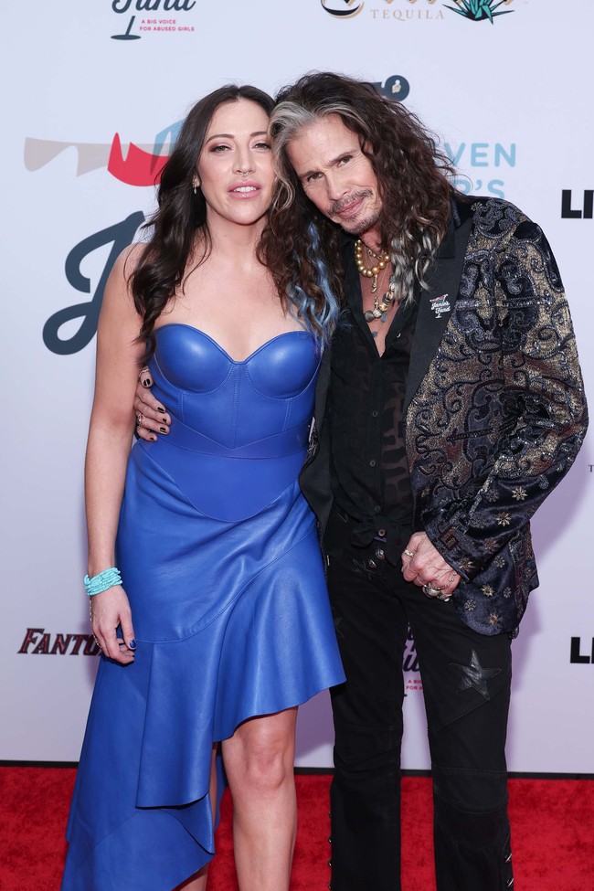 Vokalis band Aerosmith ini tak sungkan memperlihatkan kemesraan dengan sang kekasih di Jam For Janie GRAMMY Awards Viewing Party, Hollywood Palladium, Minggu (4/2/2024). Foto: Getty Images/Elyse Jankowski