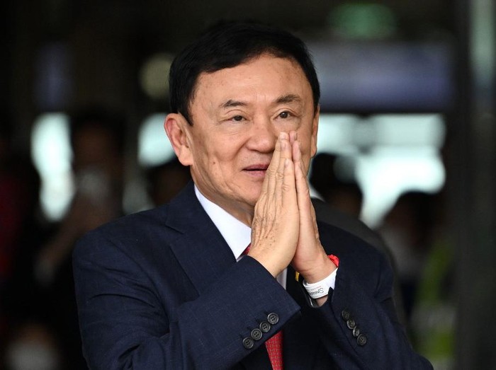 (FILES) Former Thai Prime Minister Thaksin Shinawatra greets his supporters after landing at Bangkoks Don Mueang airport on August 22, 2023. Thai police have charged former prime minister Thaksin Shinawatra with lese-majeste over comments he made almost a decade ago, officials said February 6, 2024, though it is not yet clear whether the case will go to court. (Photo by Manan VATSYAYANA / AFP)