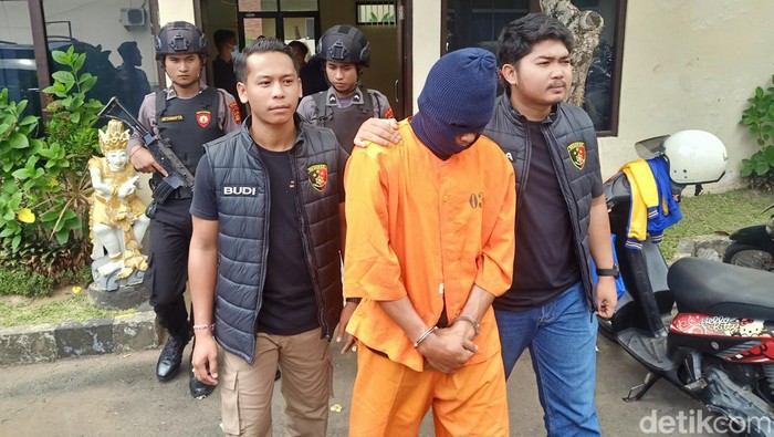 TNI gadungan asal Seririt, Buleleng, penyebar vidio bugil mantan pacar saat digiring anggota Polres Jembrana, Selasa (6/2/2024). (I Putu Adi Budiastrawan/detikBali)