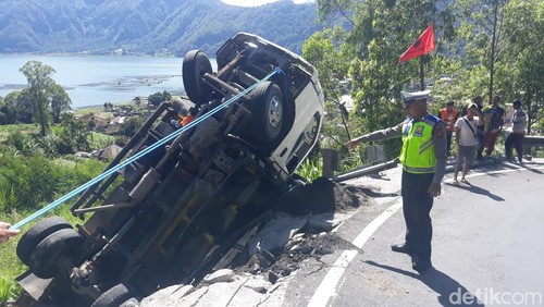 Truk bermuatan pasir terbalik dan tertahan di pembatas jalan, tepatnya di tikungan Jalur Kedisan-Penelokan, Bangli, Selasa (6/2/2024).