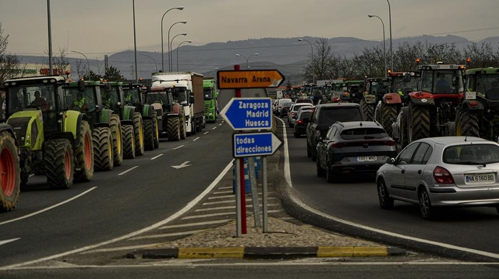 Farmers make barricades after blocking a highway during a protest near Mollerussa, northeast Spain, Tuesday, Feb. 6, 2024. From early morning, farmers across Spain have staged tractor protests across the country, blocking highways and causing traffic jams to demand changes in European Union policies and funds and measures to combat production cost hikes. (AP Photo/Emilio Morenatti)