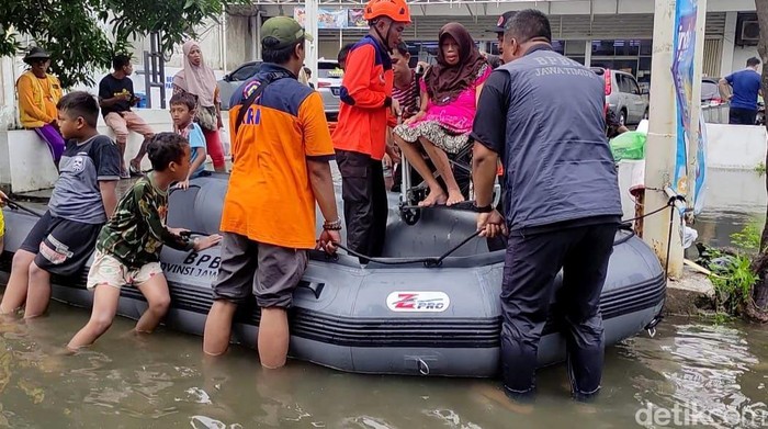 Sejumlah petugas BPBD Jawa Timur melakukan evakuasi korban banjir di Jalan Pepelegi Waru Sidoarjo, Rabu (7/2/2024).