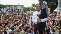 Anies terlihat sangat semringah saat menggendong seorang bocah.
