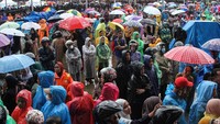 Warga mengantre di tengah guyuran hujan saat pembagian paket bantuan sosial (bansos) di Makassar, Sulawesi Selatan, Rabu (7/2/2024).