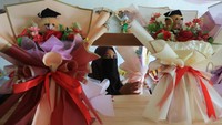 Perajin menata buket bunga dan buket boneka seusai dirangkai. 