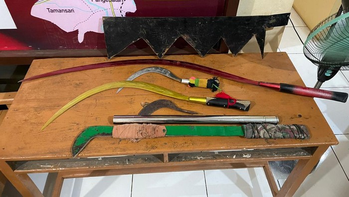 Barang bukti senjata tajam yang dibawa remaja dalam tawuran antar geng motor di jalan raya Desa Pangebatan, Kecamatan Karanglewas, Kabupaten Banyumas, Rabu (7/2/2024).