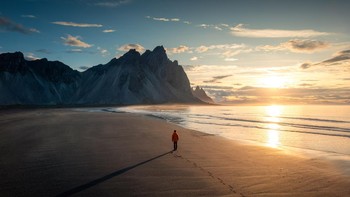 Karya Thanayu Jongwattanasilkul dari Thailand. Seorang pria berjalan di sepanjang pantai menuju gunung Vestrahorn di Islandia. Foto: Sony World Photography