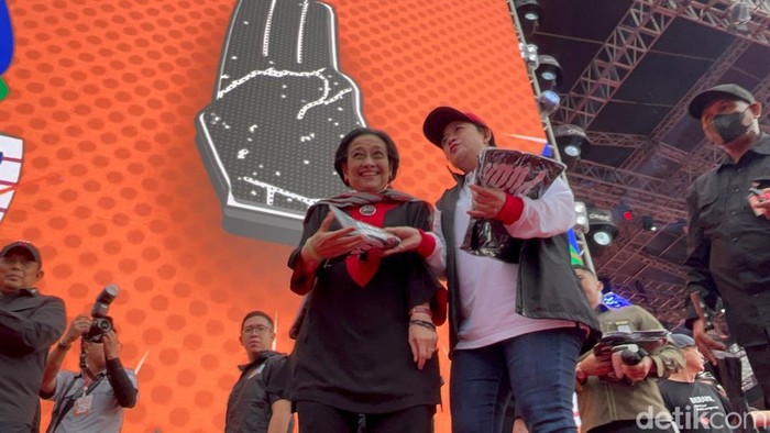 Ketua Umum PDIP Megawati Soekarnoputri membagikan kaus Ganjar Pranowo-Mahfud Md kepada para pendukung. Megawati didampingi oleh putrinya sekaligus Ketua DPP PDIP Puan Maharani. (Anggi M/detikcom)