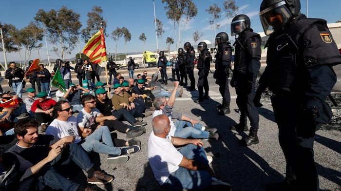 Spanish farmers gestures in front of police officers as they block access to the Castellon port during a protest against high costs, bureaucracy and competition from non-EU countries, in Castellon, Spain, February 7, 2024. REUTERS/Eva Manez