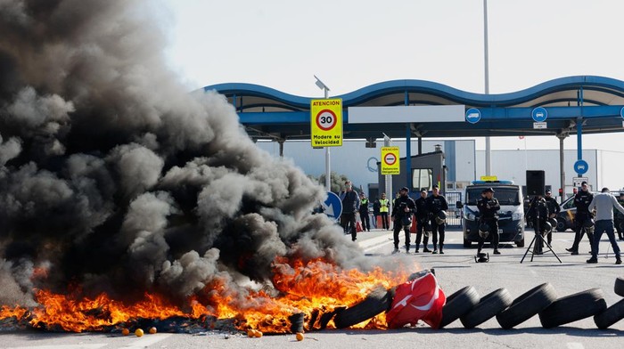 Petani di Spanyol Demo Besar-besaran, Tutup Jalan hingga Bakar Ban Spanish farmers gestures in front of police officers as they block access to the Castellon port during a protest against high costs, bureaucracy and competition from non-EU countries, in Castellon, Spain, February 7, 2024. REUTERS/Eva Manez
