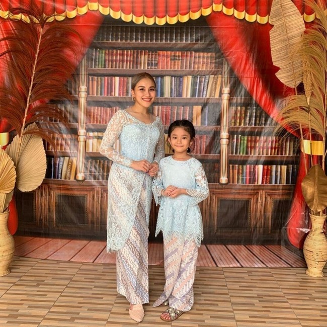 Kebaya simple jadi pilihan Ayu Ting Ting saat menghadiri wisuda adiknya, Syifa. Tampil kembaran dengan putrinya Bilqis, Ayu memilih kebaya biru brokat dari Sista Wedding. Foto: Dok. Instagram