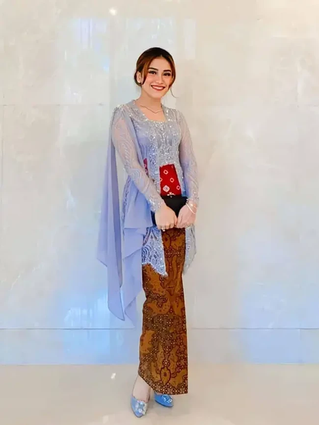 Kondangan ke pernikahan Lesti Kejora, Ayu Ting Ting terlihat memesona dalam balutan kebaya nuansa silver. Kebaya model kutu baru itu tampil modern dengan detail selendang di bahu. Foto: Dok. Instagram