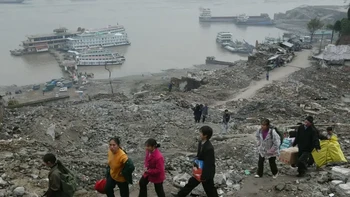 Salah satu momen penting dalam evolusi Chongqing sebagai sebuah kota terjadi pada tahun 1994, ketika pembangunan Bendungan Tiga Ngarai dimulai. Bendungan ini selesai dibangun tahun 2003. Penduduk desa berbondong-bondong ke kota karena rumah mereka tergusur proyek ini. Pada foto berikut adalah para penumpang feri berjalan melewati sisa-sisa bangunan apartemen dekat Sungai Yangtze, pada November 2002. Foto: via Business Insider