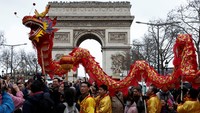 Di Paris, warga keturunan Tionghoa mengarak reprika naga di jalan Champs Elysees. Pertunjukan ini mengundang perhatian turis dan warga lokal. (REUTERS/Benoit Tessier)