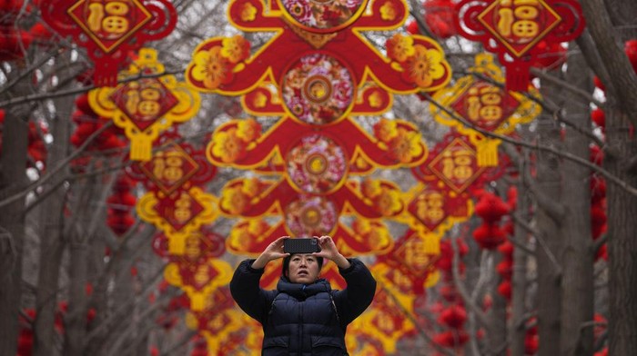 Euforia Tahun Baru Imlek Warga Tionghoa di Dunia A man and a toddler are silhouetted as they pose for a souvenir photo with a giant dragon lantern decorated near the popular Houhai Lake in Beijing, Thursday, Feb. 8, 2024. Chinese will celebrate Lunar New Year on Feb. 10 this year which marks the Year of the dragon on the Chinese zodiac. (AP Photo/Andy Wong)