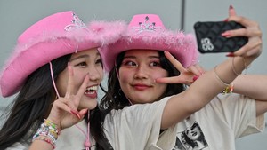 Ekspresi kawaii Swifties jelang The Eras Tour di Tokyo Dome. Selfie ria dulu! (Foto: AFP/RICHARD A. BROOKS)