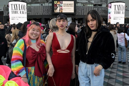 Fans of US singer Taylor Swift, also known as Swifties, who flew in from Thailand to see the show, pose for photos outside the Tokyo Dome shortly before the start of the first leg of her Asia-Pacific 