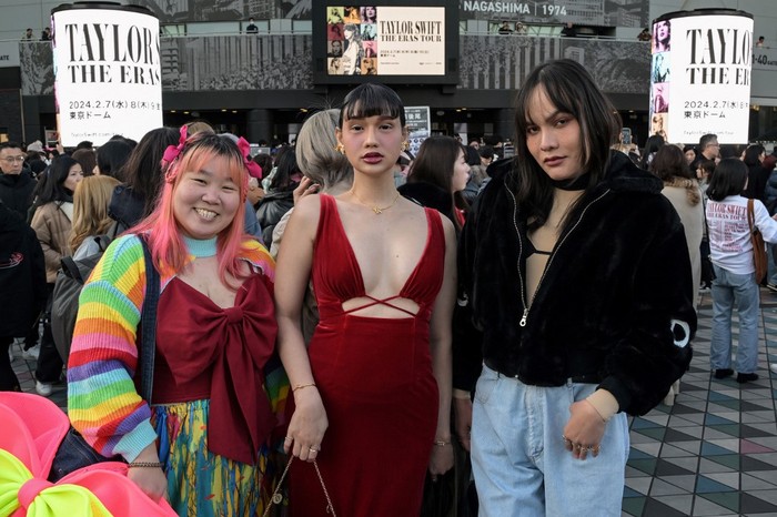 Fans of US singer Taylor Swift, also known as Swifties, who flew in from Thailand to see the show, pose for photos outside the Tokyo Dome shortly before the start of the first leg of her Asia-Pacific 