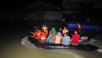 Relawan gabungan mengevakuasi warga yang terjebak banjir menggunakan perahu karet. Antara Foto/Yusuf Nugroho.