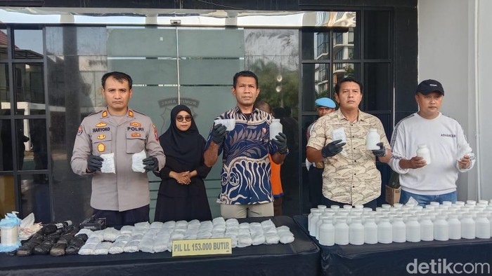 Polisi menunjukkan barang bukti ratusan ribu pil koplo yang disita dari seorang pria di Surabaya.