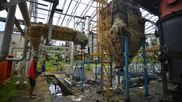 Warga melihat kondisi Pembangkit Listrik Tenaga Biomassa (PLTBm) berbahan bakar bambu yang terbengkalai di Desa Madobag, Siberut Selatan, Kabupaten Kepulauan Mentawai, Sumatera Barat, Jumat (9/2/2024). PLTBM pertama di Indonesia yang diresmikan tahun 2019 tersebut, bersama dua unit lagi hanya beroperasi selama enam bulan dengan total kapasitas 700 kW untuk menerangi 1.233 Kepala Keluarga (KK), namun kini terbengkalai dan mangkrak, sebelumnya mengalami kendala kekurangan pasokan dan rusaknya mesin. ANTARA FOTO/Iggoy el Fitra/rwa.
