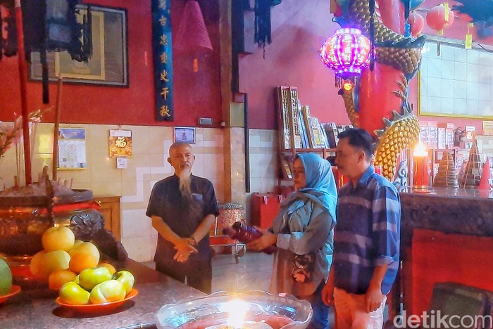 Amsah dan suami saat melakukan ritual ciam si perayan tahun baru imlek di Klenteng Bio Kwan Tee Koen Karawang