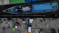 Foto udara sejumlah pekerja memindahkan logistik Pemilu 2024 ke kapal motor di dermaga feri Distrik Agats. 