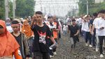 Pendukung AMIN Susuri Rel Kereta Demi Hadiri Kampanye di JIS