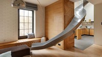 Fungsi perosotan ini bisa menggantikan tangga. Letaknya yang dekat dengan ruang keluarga dan dapur memudahkan kamu jika ingin mengambil makanan di dapur. Foto: KI Design Studio via Dezeen