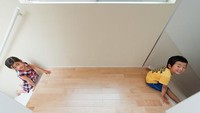 Perosotan yang satu ini cukup unik karena bentuknya melingkar rumah. Jadi, tangga untuk naik ke atas ruangan berada di sisi satu, sementara sisi satunya terdapat perosotan untuk turun ke lantai bawah. Foto: Shinichi Tanaka via Dezeen