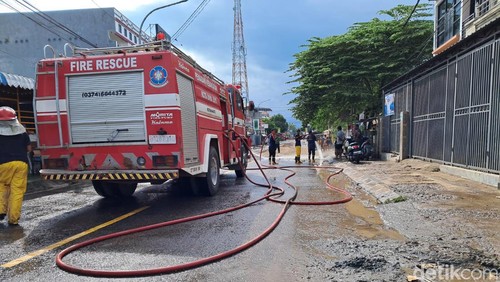Petugas pemadam kebakaran membersihkan sisa lumpur akibat banjir di sepanjang Jalan Soekarno-Hatta di Kelurahan Paruga, Kecamatan Rasbar, Bima, NTB, Sabtu (10/2/2024). (Foto: Rafiin/detikBali)