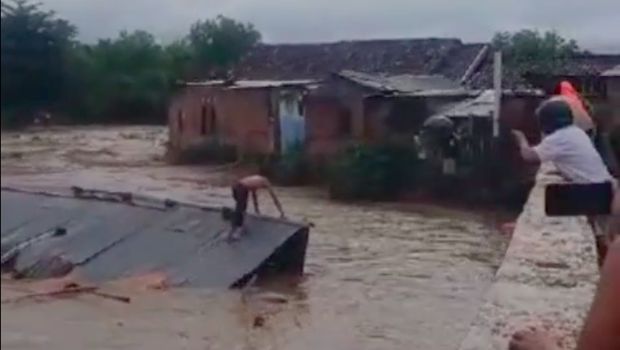 Warga terhanyut terbawa arus berdiri di atas rumah (Tangkapan layar video viral)