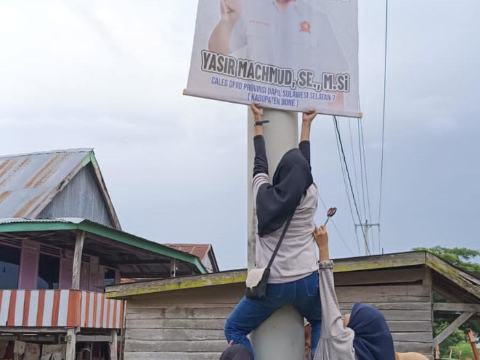 Anggota panwascam di Bone menertibkan APK di masa tenang Pemilu 2024.