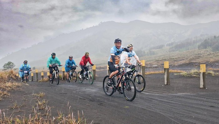 Puluhan pesepeda menikmati lautan pasir Gunung Bromo usai diguyur hujan dengan landasan yang basah. Ini foto-fotonya.