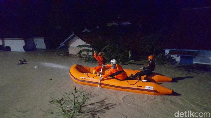 Petugas sedang berusaha mengevakuasi korban terjebak banjir di Ujungjaya, Kabupaten Sumedang, Minggu (11/2/2024) malam.