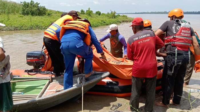 Polisi dan warga saat mengevakuasi korban tewas akibat ombak Bono