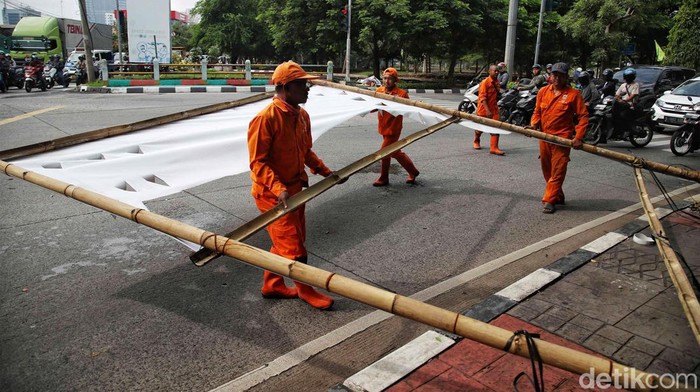 Petugas Satpol PP dan PPSU melakukan penertiban alat peraga kampanya (APK) di kawasan Kelurahan Sunter Jaya, Jakarta Utara, Senin (12/2/2024).