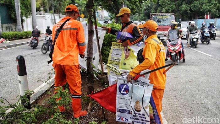 Petugas Satpol PP dan PPSU melakukan penertiban alat peraga kampanya (APK) di kawasan Kelurahan Sunter Jaya, Jakarta Utara, Senin (12/2/2024).