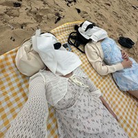 Pantai menjadi destinasi favoritnya. Dalam salah satu foto, Eunbi dan Minju berpose lucu saat berjemur. Wajah keduanya ditutupi dengan beberapa helai tisu hingga tidak terlihat, ditambah dengan kacamata hitam. Foto: dok. Instagram @silver_rain.__