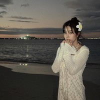 Pelantun ‘Flash’ itu juga pergi ke pantai untuk mengejar sunset. Seperti dalam foto ini, Kwon Eunbi terlihat anggun memakai dress putih. Penampilannya dipermanis dengan aksesori berbentuk bunga kamboja. Foto: dok. Instagram @silver_rain.__