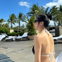 Dalam postingan Instagram terbarunya, Kwon Eunbi tampil seksi saat berenang di penginapan mewahnya. Dia mengenakan bikini hitam dengan detail strap putih. Tak sedikit penggemar yang salah fokus dengan tatonya di bagian punggung. Foto: dok. Instagram @silver_rain.__