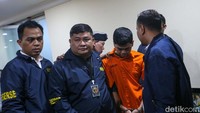 Yudha kini mengenakan baju tahanan berwarna oranye lengkap dengan tangan terborgol.  