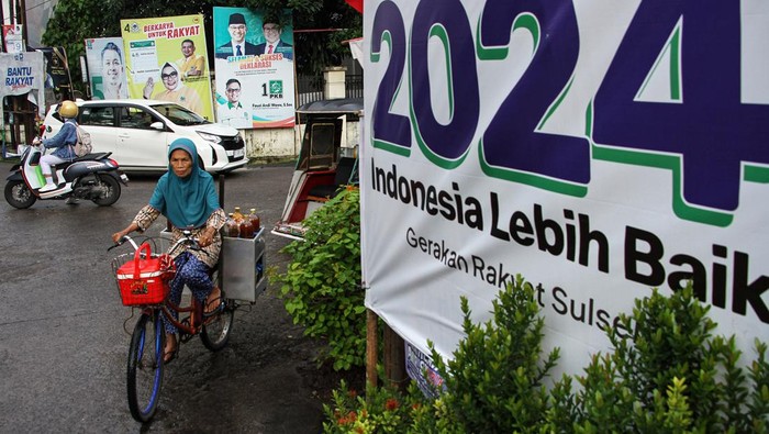 Warga melintas di depan alat peraga kampanye (APK) di Makassar, Sulawesi Selatan, Senin (12/2/2024). Memasuki hari kedua masa tenang Pemilu 2024 sejumlah APK di beberapa titik di daerah itu belum ditertibkan. ANTARA FOTO/Arnas Padda/foc.