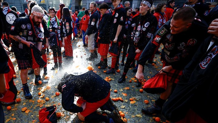 Melihat Perang Jeruk Tahunan di Italia Revellers take part in a fight with oranges during an annual carnival battle in Ivrea, Italy, February 11, 2024. REUTERS/Guglielmo Mangiapane