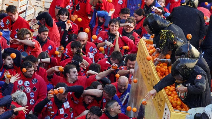 Revellers take part in a fight with oranges during an annual carnival battle in Ivrea, Italy, February 11, 2024. REUTERS/Guglielmo Mangiapane